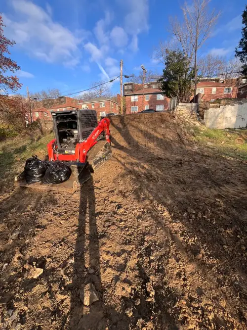 Site grading and excavation work with Kubota skid steer on residential property.