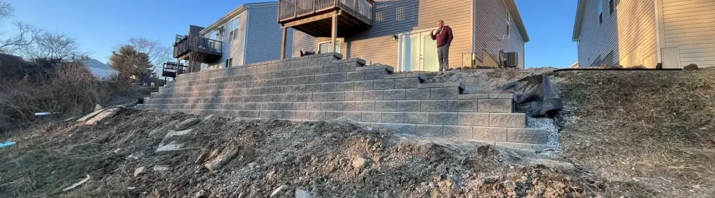 Modular block retaining wall with steps behind residential homes.