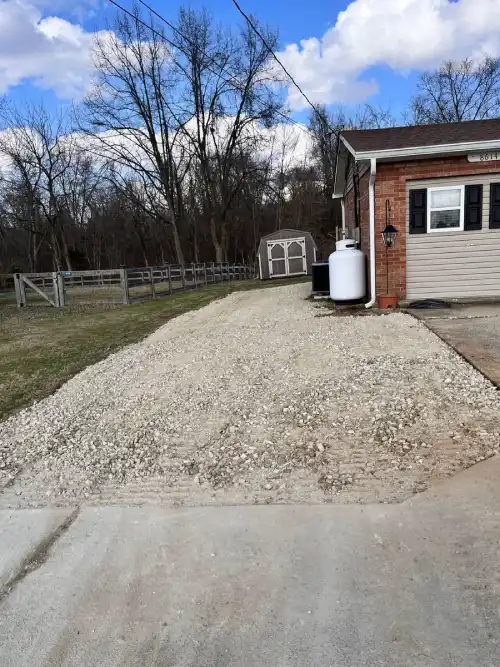 Finished gravel driveway beside residential home.